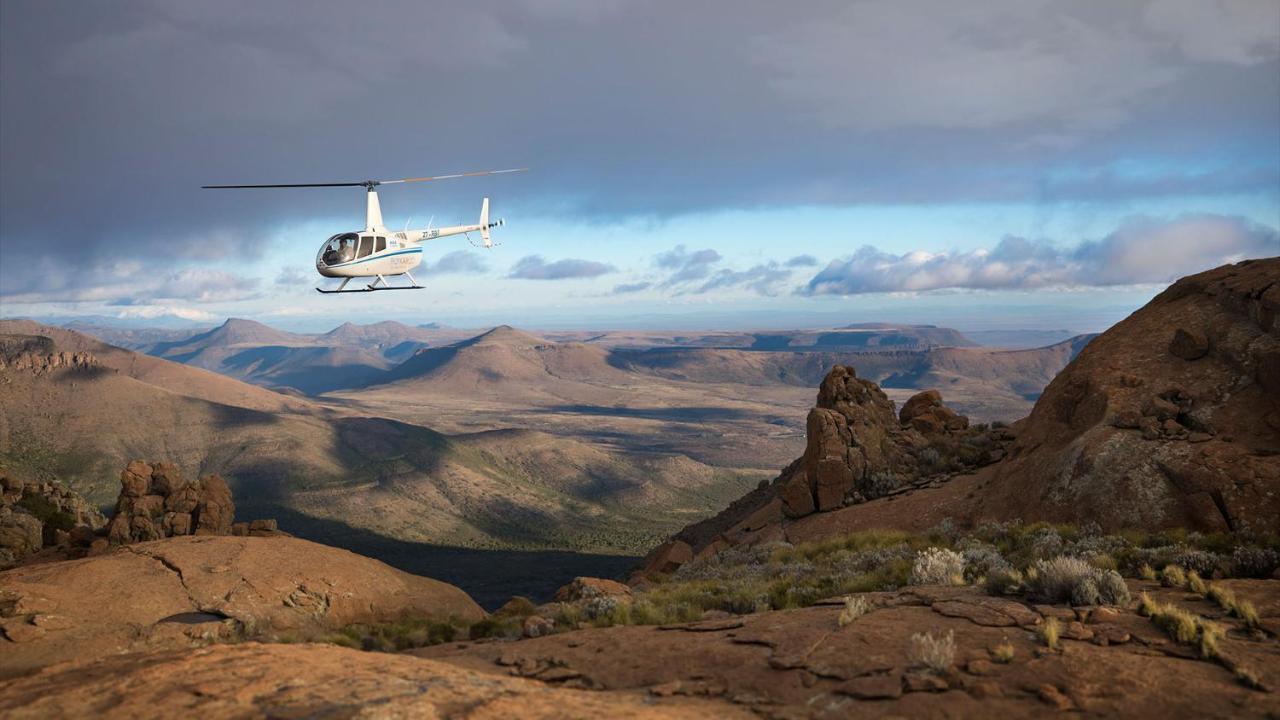 Drostdy Hotel Храфф-Рейнет Экстерьер фото A Robinson R44 helicopter flying over the Namib Desert